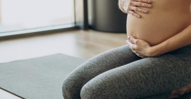 Pilates in gravidanza donna che si tiene il pancione